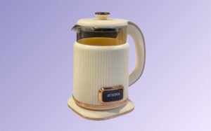 A white and gold French press coffee maker with a glass body and metal lid, set against a neutral background