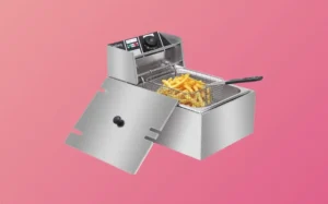A fryer filled with golden fries, set against a vibrant pink background.