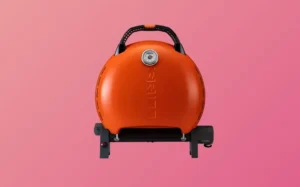A small orange suitcase placed on a pink background, showcasing its vibrant color and compact design.