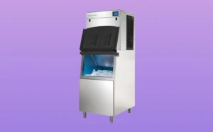 A commercial ice machine against a blue background, showcasing its sleek design and functionality for ice production.